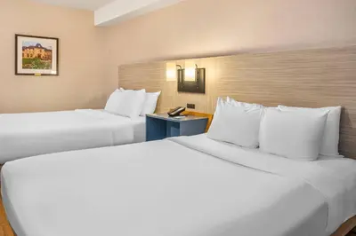 two beds in a hotel room with white pillows at Comfort Inn in Laval