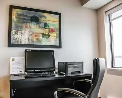 a desk with a laptop computer and a printer at Comfort Inn in Laval