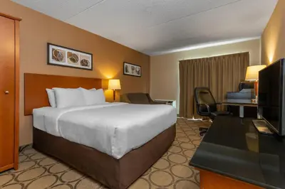 a hotel room with a bed and a desk and a television at Comfort Inn Sherbrooke in Sherbrooke