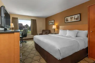 a hotel room with a bed and a flat screen tv at Comfort Inn in Drummondville