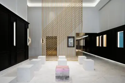 a lobby with white chairs and a gold wall at Four Seasons Hotel Montreal in Montréal