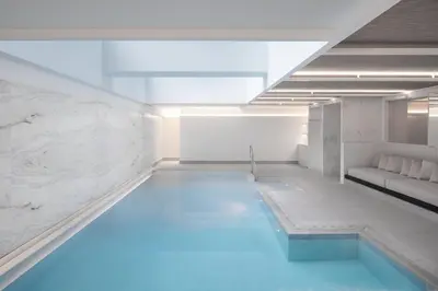 a swimming pool with blue water in a white room at Four Seasons Hotel Montreal in Montréal