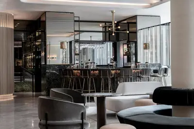 a lobby with a bar with chairs and tables at Four Seasons Hotel Montreal in Montréal