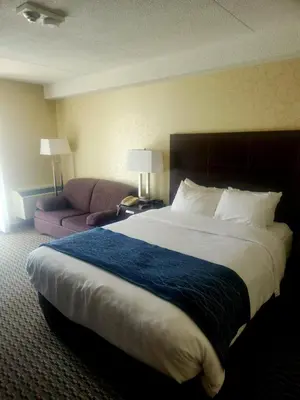 a hotel room with a large bed and a couch at Comfort Inn in Trois-Rivières