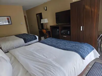 a hotel room with two beds and a flat screen tv at Comfort Inn in Trois-Rivières
