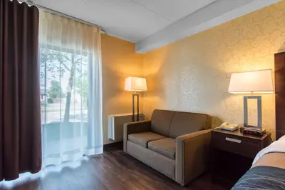 a hotel room with a couch and a window at Comfort Inn in Trois-Rivières