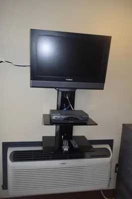 a flat screen tv sitting on top of a tv stand at Motel Falcon in Brossard