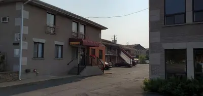 an empty street in a city with buildings at Motel Falcon in Brossard