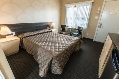 a hotel room with a bed and a desk at Motel Falcon in Brossard