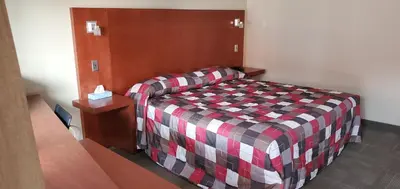 a bedroom with a bed and a couch in it at Motel Falcon in Brossard