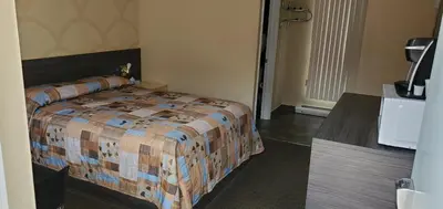 a hotel room with a bed in a room at Motel Falcon in Brossard