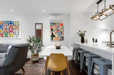 a kitchen and dining room with a white table and chairs at LiV MTL Soho in Montréal