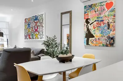 a white dining room with a white table and chairs at LiV MTL Soho in Montréal