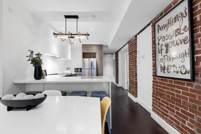 a kitchen and dining room with a brick wall at LiV MTL Soho in Montréal