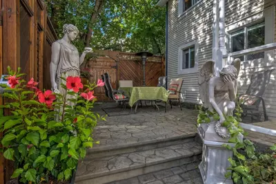 a patio with two statues and flowers and a table at Auberge Marquis de Montcalm in Sherbrooke