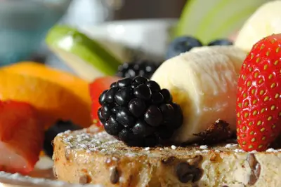 a plate of fruit on a plate with toast at Auberge Marquis de Montcalm in Sherbrooke