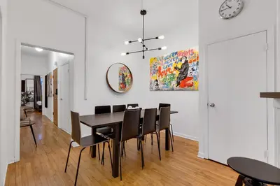 a dining room with a table and chairs and a clock at LiV MTL Avenue in Montréal