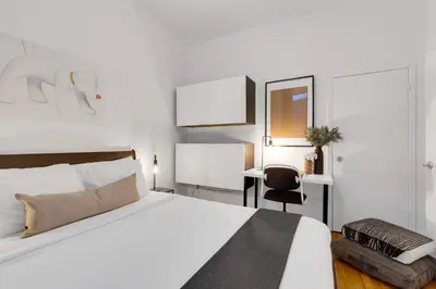 a bedroom with a bed and a chair and a desk at LiV MTL Avenue in Montréal