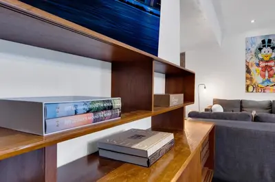 a living room with a book shelf with books at LiV MTL Plato in Montréal