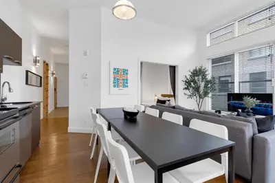 a kitchen and living room with a table and a couch at LiV MTL Main in Montréal