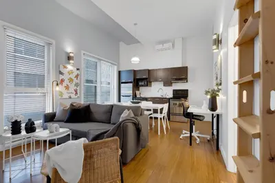 a living room with a couch and a kitchen at LiV MTL Main in Montréal
