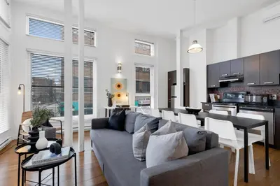 a living room with a couch and a kitchen at LiV MTL Main in Montréal