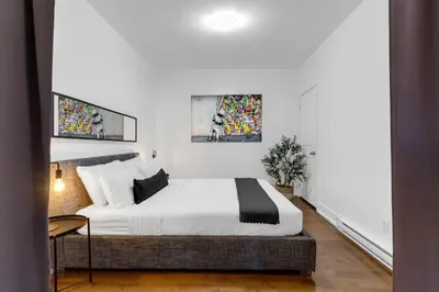 a bedroom with a bed and two pictures on the wall at LiV MTL Chic in Montréal