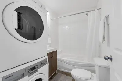 a white bathroom with a toilet and a sink at LiV MTL MTL in Montréal