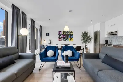 a living room with two couches and blue chairs at LiV MTL Downtown in Montréal