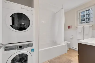a white laundry room with a washer and dryer at LiV MTL Downtown in Montréal