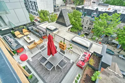 an aerial view of a balcony with chairs and tables at LiV MTL Downtown in Montréal