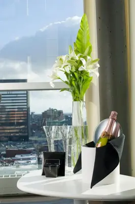 a vase with flowers on a table with a window at Hotel Zero 1 Montreal in Montréal