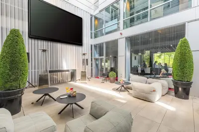 a lobby with chairs and tables and a flat screen tv at Hotel Zero 1 Montreal in Montréal