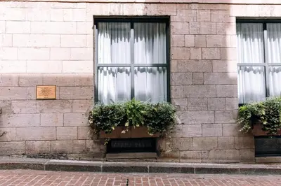 a brick building with two windows with plants at Maison Sainte-Thérèse By Maisons & co in Montréal