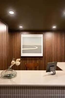 a desk with a vase of flowers and a picture at Maison Sainte-Thérèse By Maisons & co in Montréal