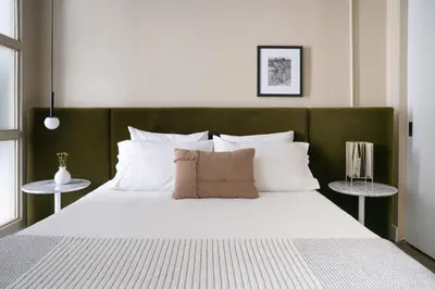 a large bed with a green headboard and white pillows at Maison Sainte-Thérèse By Maisons & co in Montréal