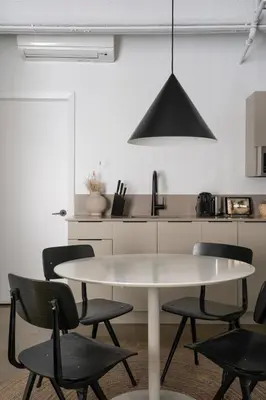 a white kitchen with a white table and chairs at Maison Sainte-Thérèse By Maisons & co in Montréal