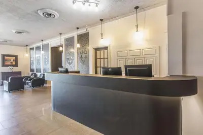 a lobby with a bar with chairs in it at Hôtel Le Principal in Granby