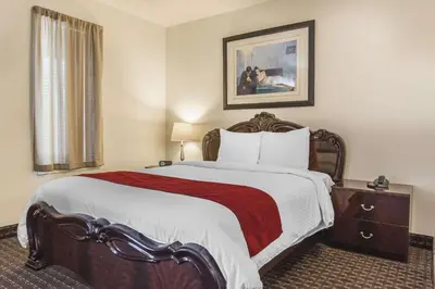 a bedroom with a large bed with a red blanket at Hôtel Le Principal in Granby