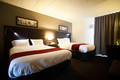 a hotel room with two beds in a room at Hôtel Le Principal in Granby