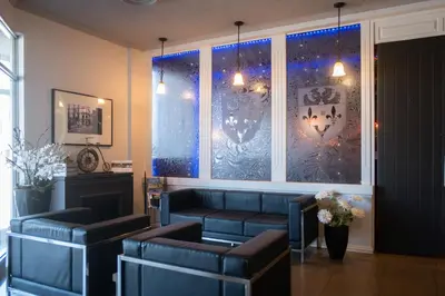 a waiting room with a couch and a window at Hôtel Le Principal in Granby