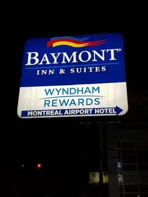 a sign for a banquet inn and suites on a building at Baymont by Wyndham Montreal Airport in Dorval