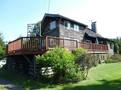 a house with a deck on the side of it at B&B Pinorama in Sutton