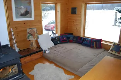 a room with a bed and a fireplace in a cabin at B&B Pinorama in Sutton