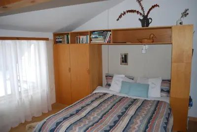 a bedroom with a bed with a wooden headboard at B&B Pinorama in Sutton