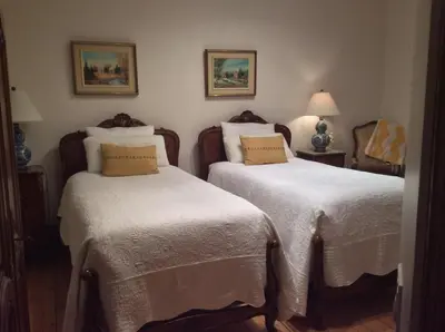 a bedroom with two beds with white sheets at Île de Garde B&B in Sherbrooke