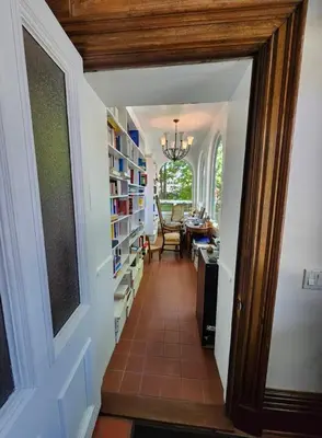 a hallway of a home with a room with bookshelves at Île de Garde B&B in Sherbrooke