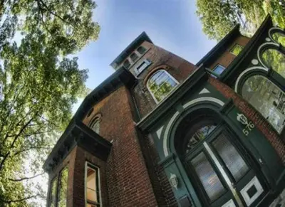 a brick building with a clock tower on top of it at Île de Garde B&B in Sherbrooke