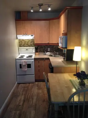 a kitchen with a stove and a table with a dining room at Studiotel Bromont in Bromont