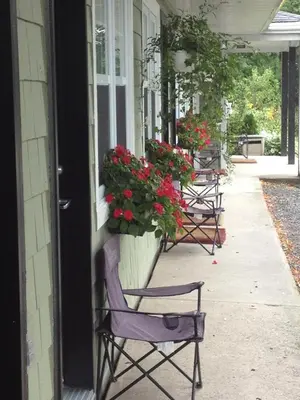 a row of chairs sitting on a porch with flowers at Studiotel Bromont in Bromont